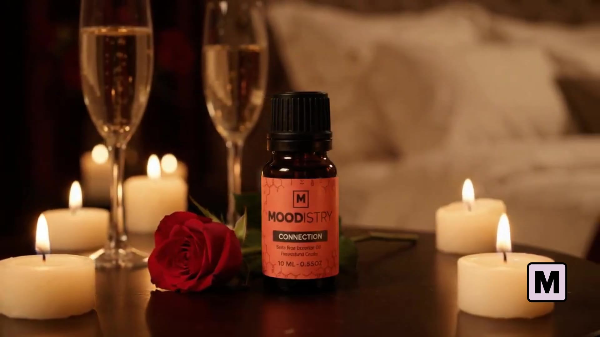 Moodistry Connection oil beside a rose and warm date-night candlelight